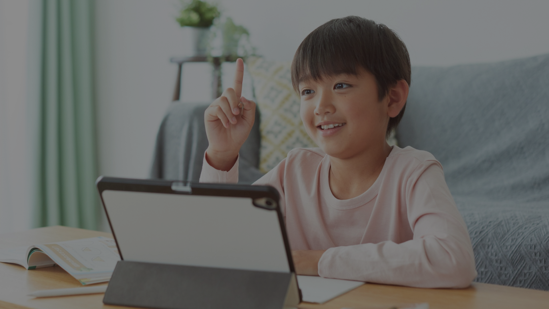 Young girl with headphones smiling during online elementary school class